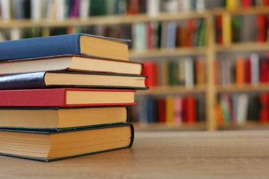 Kütüphanedeki masanın üzerinde kitap yığını