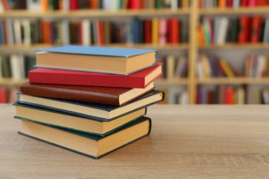 Kütüphanedeki masanın üzerinde kitap yığını