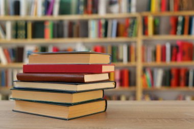 Kütüphanedeki masanın üzerinde kitap yığını