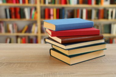 Kütüphanedeki masanın üzerinde kitap yığını