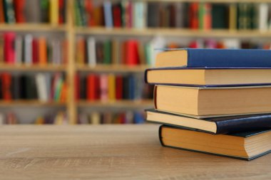 Kütüphanedeki masanın üzerinde kitap yığını