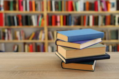 Kütüphanedeki masanın üzerinde kitap yığını