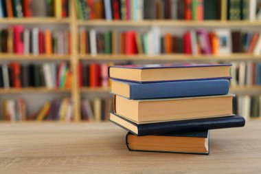 Kütüphanedeki masanın üzerinde kitap yığını