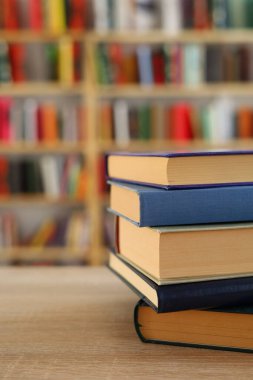 Kütüphanedeki masanın üzerinde kitap yığını