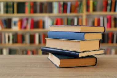 Kütüphanedeki masanın üzerinde kitap yığını