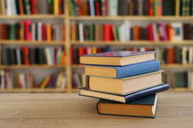 Kütüphanedeki masanın üzerinde kitap yığını