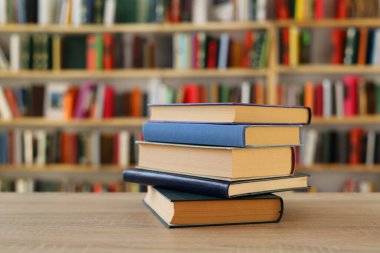 Kütüphanedeki masanın üzerinde kitap yığını