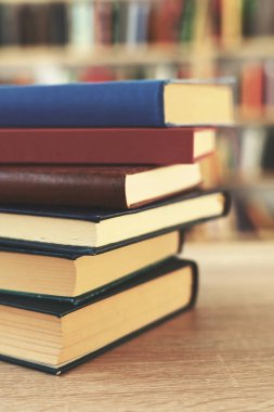 Tahta masadaki kitap yığını, Al.