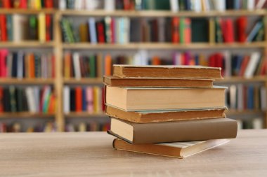Ahşap zemin üzerine kitap yığını, kütüphanenin arka planına karşı kitap yığını, kütüphanenin önünde kitap yığını, ahşap masa, eğitim, yüksek kaliteli kitap fotoğrafçılığı, En İyi Kitap Fotoğrafı