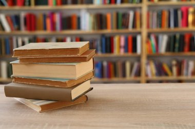 Ahşap zemin üzerine kitap yığını, kütüphanenin arka planına karşı kitap yığını, kütüphanenin önünde kitap yığını, ahşap masa, eğitim, yüksek kaliteli kitap fotoğrafçılığı, En İyi Kitap Fotoğrafı