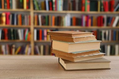 Ahşap zemin üzerine kitap yığını, kütüphanenin arka planına karşı kitap yığını, kütüphanenin önünde kitap yığını, ahşap masa, eğitim, yüksek kaliteli kitap fotoğrafçılığı, En İyi Kitap Fotoğrafı