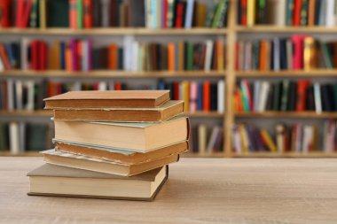 Ahşap zemin üzerine kitap yığını, kütüphanenin arka planına karşı kitap yığını, kütüphanenin önünde kitap yığını, ahşap masa, eğitim, yüksek kaliteli kitap fotoğrafçılığı, En İyi Kitap Fotoğrafı