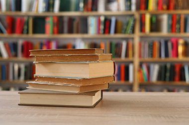 Ahşap zemin üzerine kitap yığını, kütüphanenin arka planına karşı kitap yığını, kütüphanenin önünde kitap yığını, ahşap masa, eğitim, yüksek kaliteli kitap fotoğrafçılığı, En İyi Kitap Fotoğrafı