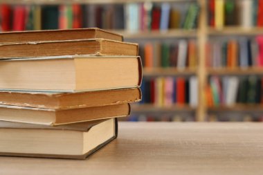 Ahşap zemin üzerine kitap yığını, kütüphanenin arka planına karşı kitap yığını, kütüphanenin önünde kitap yığını, ahşap masa, eğitim, yüksek kaliteli kitap fotoğrafçılığı, En İyi Kitap Fotoğrafı