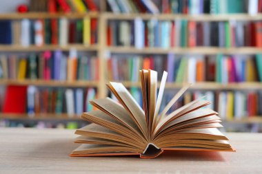 Tahta masadaki kitap yığını, açık bir kitap bilginin, bilginin, bilgeliğin ve bilginin ulaşılabilirliğinin sembolüdür. Aynı zamanda şeffaflığı ve fikirleri paylaşma isteğini sembolize edebilir..