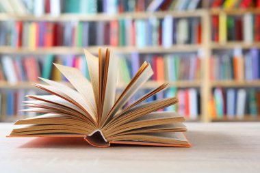 Tahta masadaki kitap yığını, açık bir kitap bilginin, bilginin, bilgeliğin ve bilginin ulaşılabilirliğinin sembolüdür. Aynı zamanda şeffaflığı ve fikirleri paylaşma isteğini sembolize edebilir..