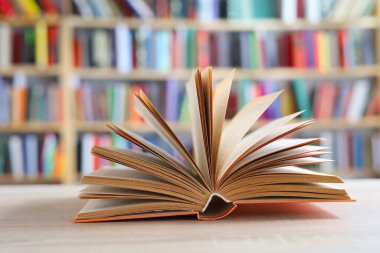 Tahta masadaki kitap yığını, açık bir kitap bilginin, bilginin, bilgeliğin ve bilginin ulaşılabilirliğinin sembolüdür. Aynı zamanda şeffaflığı ve fikirleri paylaşma isteğini sembolize edebilir..