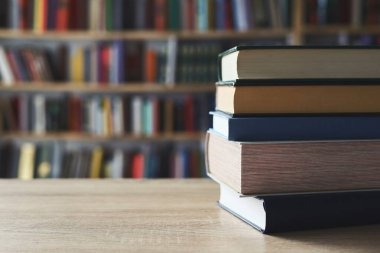 Masadaki kitaplar, ahşap zemin üzerine kitaplar, yakın plan. Kütüphanenin arka planına karşı kitaplar yığını, kütüphanenin önündeki kitaplar, ahşap masa üzerine kitaplar, eğitim, yüksek kaliteli kitap fotoğrafçılığı, En İyi Kitap Fotoğrafı, Yapay Zeka, dünyanın en iyi yazarları.