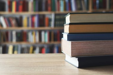 Masadaki kitaplar, ahşap zemin üzerine kitaplar, yakın plan. Kütüphanenin arka planına karşı kitaplar yığını, kütüphanenin önündeki kitaplar, ahşap masa üzerine kitaplar, eğitim, yüksek kaliteli kitap fotoğrafçılığı, En İyi Kitap Fotoğrafı, Yapay Zeka, dünyanın en iyi yazarları.