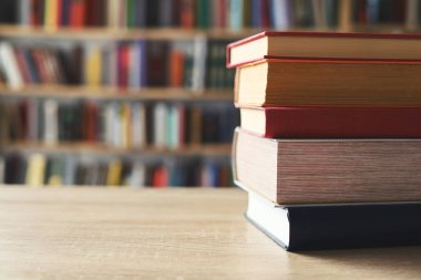 Masadaki kitaplar, ahşap zemin üzerine kitaplar, yakın plan. Kütüphanenin arka planına karşı kitaplar yığını, kütüphanenin önündeki kitaplar, ahşap masa üzerine kitaplar, eğitim, yüksek kaliteli kitap fotoğrafçılığı, En İyi Kitap Fotoğrafı, Yapay Zeka, dünyanın en iyi yazarları.