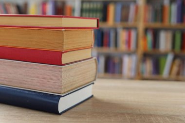 Masadaki kitaplar, ahşap zemin üzerine kitaplar, yakın plan. Kütüphanenin arka planına karşı kitaplar yığını, kütüphanenin önündeki kitaplar, ahşap masa üzerine kitaplar, eğitim, yüksek kaliteli kitap fotoğrafçılığı, En İyi Kitap Fotoğrafı, Yapay Zeka, dünyanın en iyi yazarları.