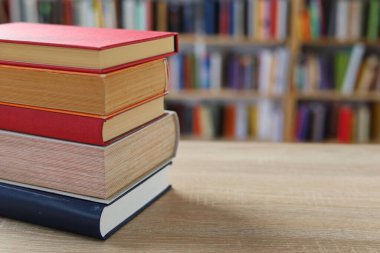 Masadaki kitaplar, ahşap zemin üzerine kitaplar, yakın plan. Kütüphanenin arka planına karşı kitaplar yığını, kütüphanenin önündeki kitaplar, ahşap masa üzerine kitaplar, eğitim, yüksek kaliteli kitap fotoğrafçılığı, En İyi Kitap Fotoğrafı, Yapay Zeka, dünyanın en iyi yazarları.