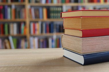 Masadaki kitaplar, ahşap zemin üzerine kitaplar, yakın plan. Kütüphanenin arka planına karşı kitaplar yığını, kütüphanenin önündeki kitaplar, ahşap masa üzerine kitaplar, eğitim, yüksek kaliteli kitap fotoğrafçılığı, En İyi Kitap Fotoğrafı, Yapay Zeka, dünyanın en iyi yazarları.