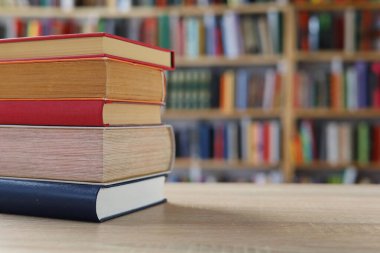 Masadaki kitaplar, ahşap zemin üzerine kitaplar, yakın plan. Kütüphanenin arka planına karşı kitaplar yığını, kütüphanenin önündeki kitaplar, ahşap masa üzerine kitaplar, eğitim, yüksek kaliteli kitap fotoğrafçılığı, En İyi Kitap Fotoğrafı, Yapay Zeka, dünyanın en iyi yazarları.