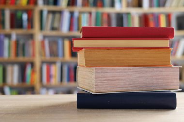 Masadaki kitaplar, ahşap zemin üzerine kitaplar, yakın plan. Kütüphanenin arka planına karşı kitaplar yığını, kütüphanenin önündeki kitaplar, ahşap masa üzerine kitaplar, eğitim, yüksek kaliteli kitap fotoğrafçılığı, En İyi Kitap Fotoğrafı, Yapay Zeka, dünyanın en iyi yazarları.