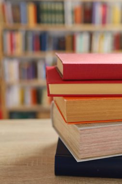 Masadaki kitaplar, ahşap zemin üzerine kitaplar, yakın plan. Kütüphanenin arka planına karşı kitaplar yığını, kütüphanenin önündeki kitaplar, ahşap masa üzerine kitaplar, eğitim, yüksek kaliteli kitap fotoğrafçılığı, En İyi Kitap Fotoğrafı, Yapay Zeka, dünyanın en iyi yazarları.