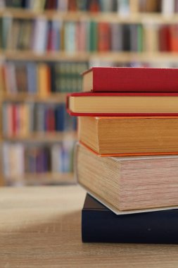 Masadaki kitaplar, ahşap zemin üzerine kitaplar, yakın plan. Kütüphanenin arka planına karşı kitaplar yığını, kütüphanenin önündeki kitaplar, ahşap masa üzerine kitaplar, eğitim, yüksek kaliteli kitap fotoğrafçılığı, En İyi Kitap Fotoğrafı, Yapay Zeka, dünyanın en iyi yazarları.