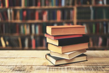 Tahta masanın üzerinde bir yığın eski kitap. Metin için boşluk