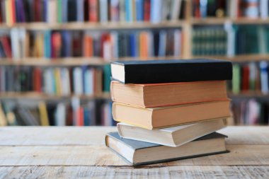 Kütüphanedeki masada yığınla kitap var.