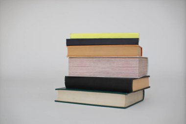 Beyaz arkaplanda bir yığın kitap.