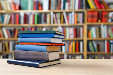 Rafta kitap ve bardak yığını var.