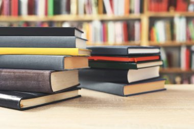 Kütüphanede ahşap arkaplan üzerine kitap yığını