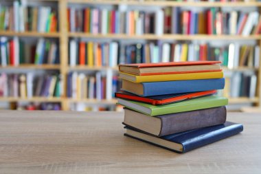 Kütüphanedeki masanın üzerinde kitap yığını