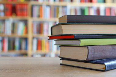 Kütüphanedeki masanın üzerinde kitap yığını
