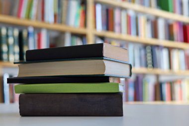 Kütüphanedeki masanın üzerinde kitap yığını