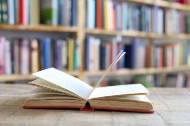 Tahta masanın üzerinde bir yığın ciltli kitabın olduğu açık bir kitap. Okula dönüyorum. Boşluğu kopyala.