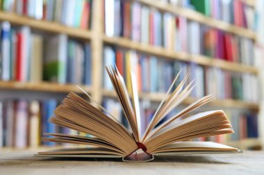 Kütüphanedeki ahşap masada yığınla kitap.