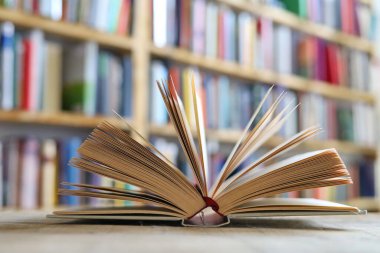 Açılmış kitap, ahşap masada ciltli kitaplar..