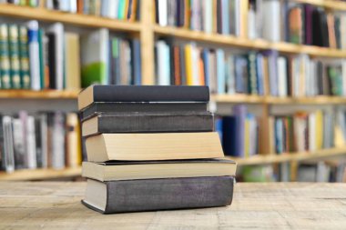 Kütüphanedeki masanın üzerinde kitap yığını