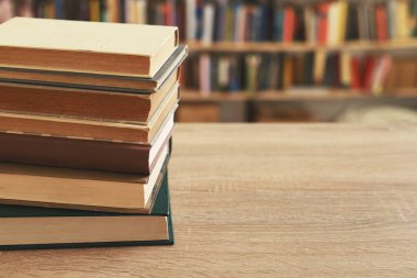 Tahta masadaki kitap yığını.