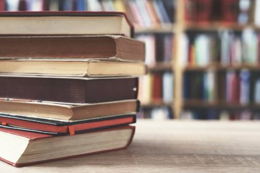 Tahta masanın üzerinde bir yığın eski kitap.