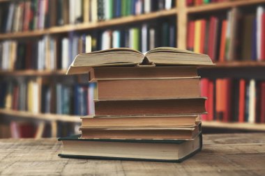 Kütüphanedeki masanın üzerinde kitap yığını