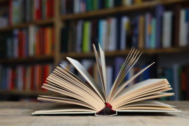Tahta masanın üzerinde kitaplar olan defteri aç