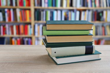 Kütüphanedeki masanın üzerinde kitap yığını