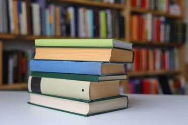 Kütüphanedeki masanın üzerinde kitap yığını