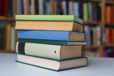 Kütüphanedeki masanın üzerinde kitap yığını